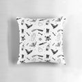 A decorative pillow featuring a moody, mysterious design with gothic and macabre elements like skulls, bats, and occult symbols.