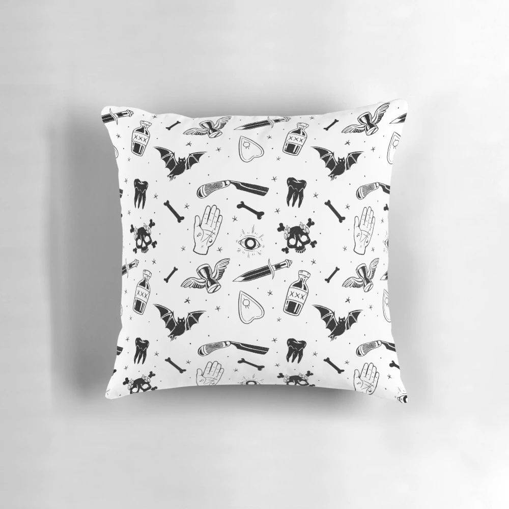 A decorative pillow featuring a moody, mysterious design with gothic and macabre elements like skulls, bats, and occult symbols.