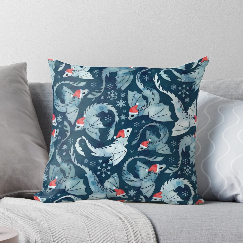 A blue decorative pillow featuring a whimsical dragon surrounded by a watercolor snowflake design, perfect for holiday and winter décor.