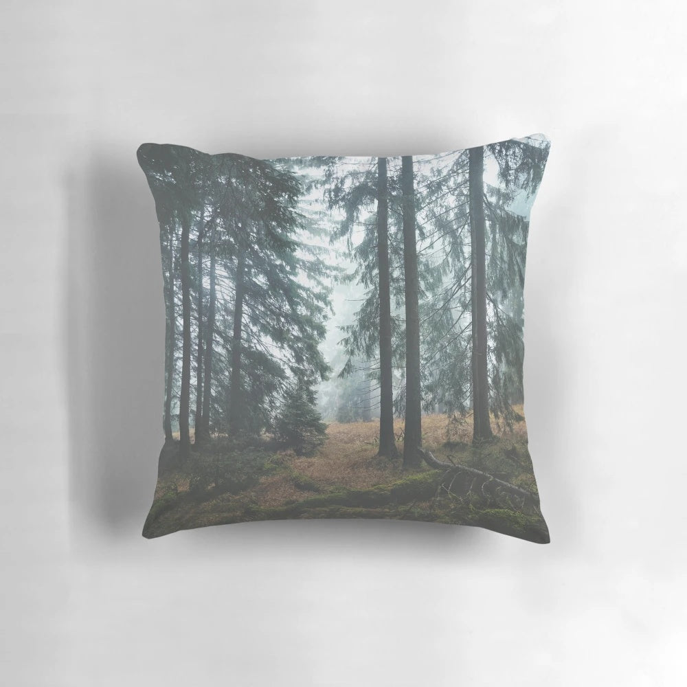 A cozy pillow featuring a dreamy, misty forest scene with dark trees and an autumn mood