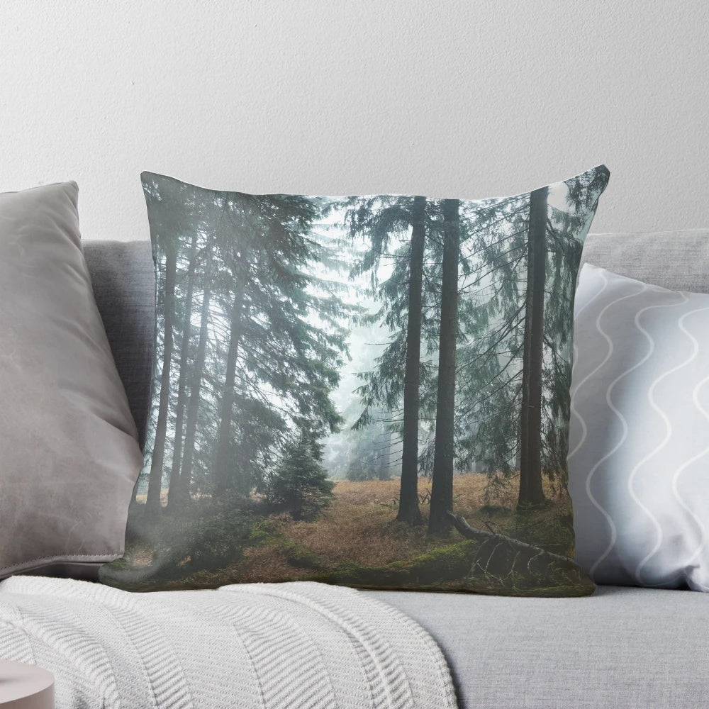 A cozy pillow featuring a dreamy, misty forest scene with dark trees and an autumn mood
