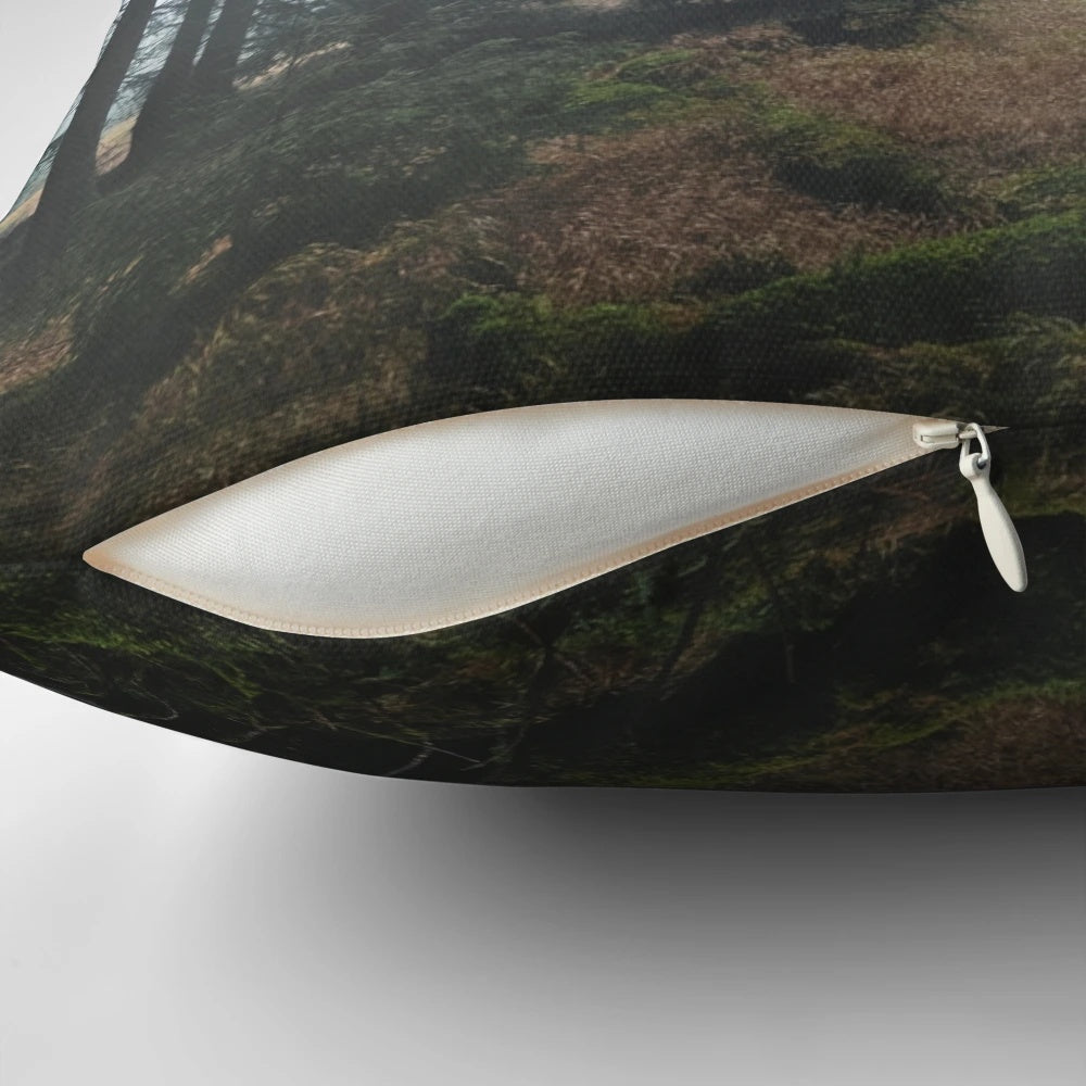 A cozy pillow featuring a dreamy, misty forest scene with dark trees and an autumn mood