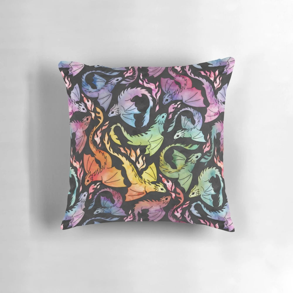 Watercolor illustration of a cute, fire-breathing dragon on a dark background with a vibrant rainbow.