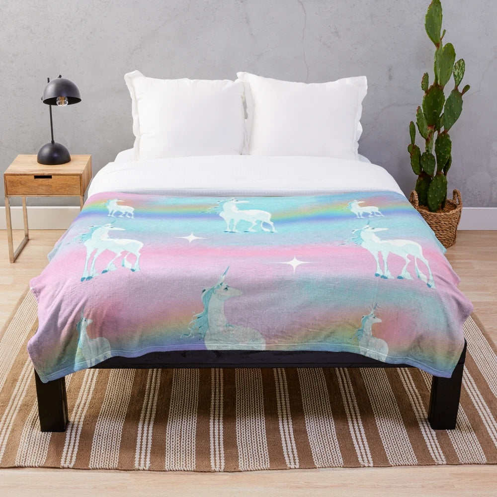 Soft, pastel-colored plush blanket featuring a dreamy rainbow print, inspired by the classic animated film "The Last Unicorn
