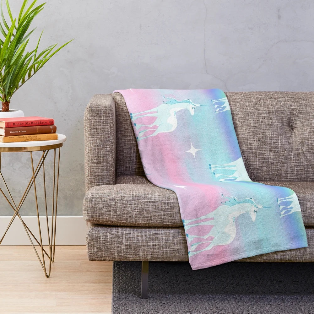 Soft, pastel-colored plush blanket featuring a dreamy rainbow print, inspired by the classic animated film "The Last Unicorn