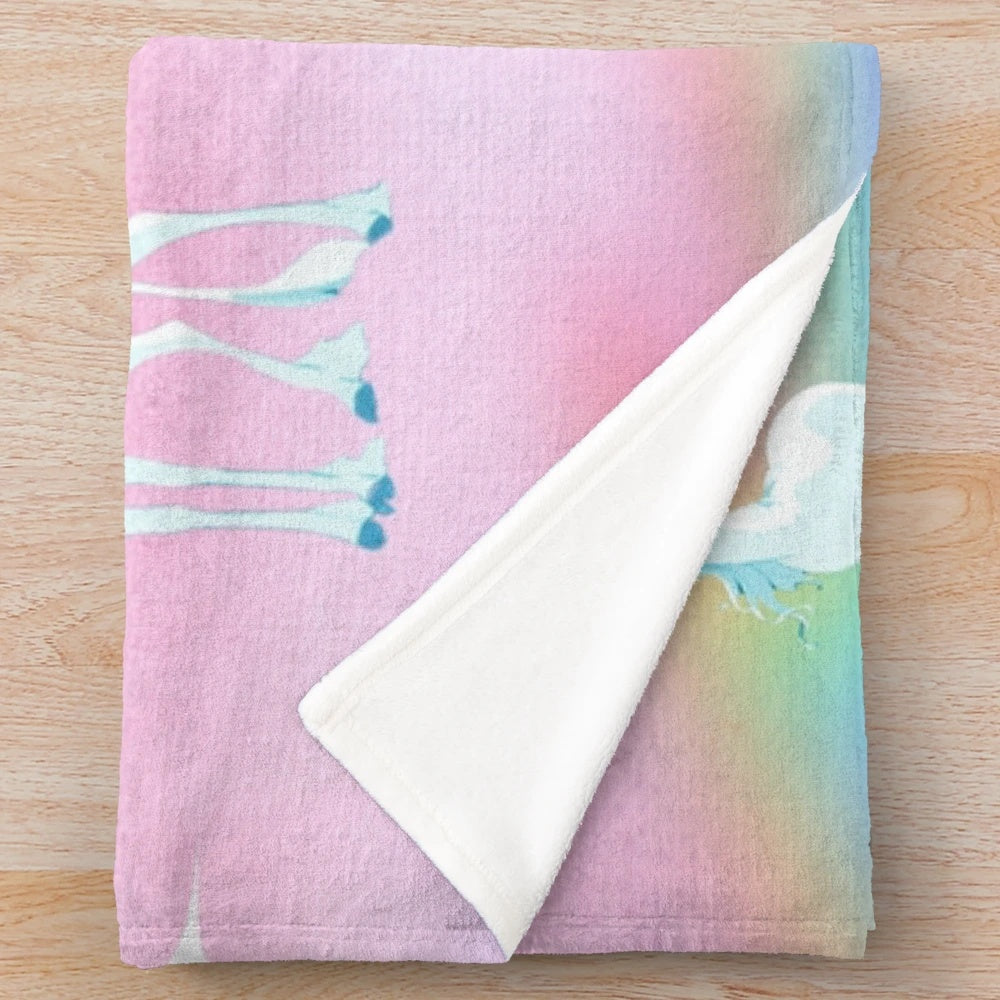 Soft, pastel-colored plush blanket featuring a dreamy rainbow print, inspired by the classic animated film "The Last Unicorn