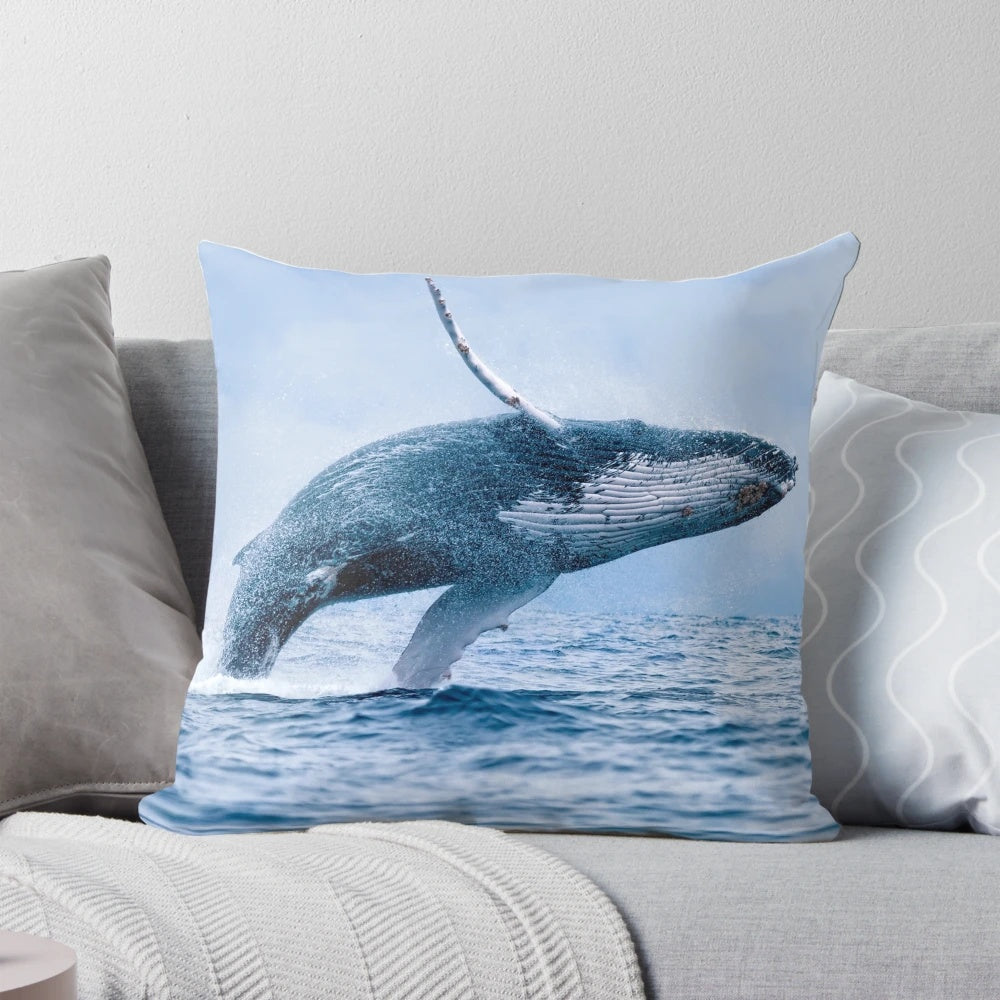 A pillow featuring a realistic image of a humpback whale breaching the ocean surface