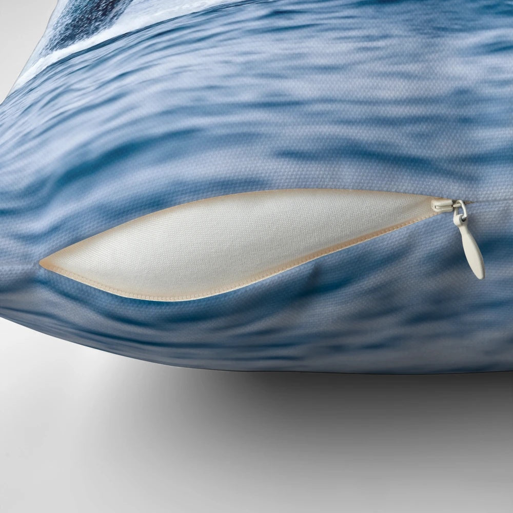 A pillow featuring a realistic image of a humpback whale breaching the ocean surface
