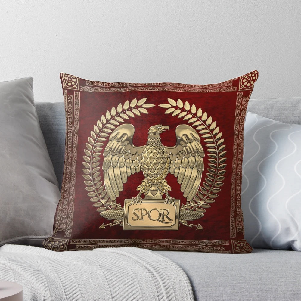Photograph of a decorative pillow featuring a gold imperial eagle design on red velvet background