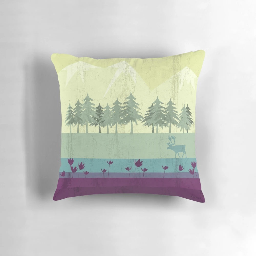 A vibrant, nature-inspired pillow featuring a deer against a backdrop of forests, mountains, and a gradient of colors