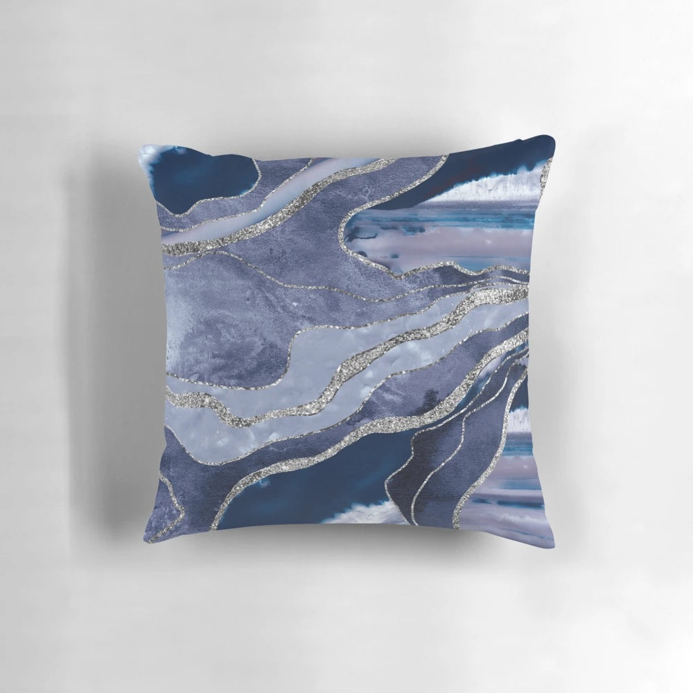 A decorative pillow showcasing a vibrant blue and silver marbled agate design.