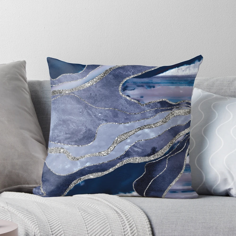 A decorative pillow showcasing a vibrant blue and silver marbled agate design.
