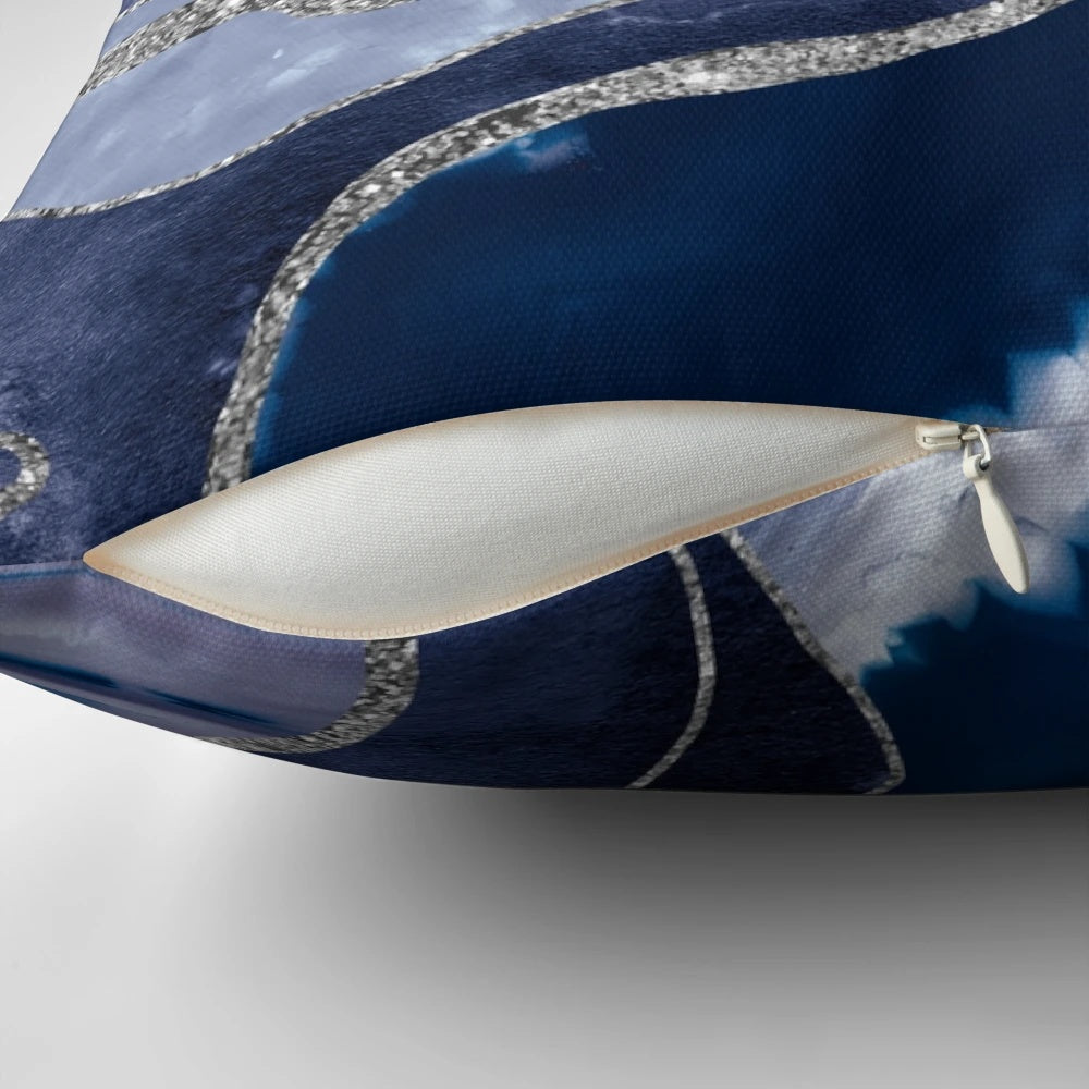 A decorative pillow showcasing a vibrant blue and silver marbled agate design.