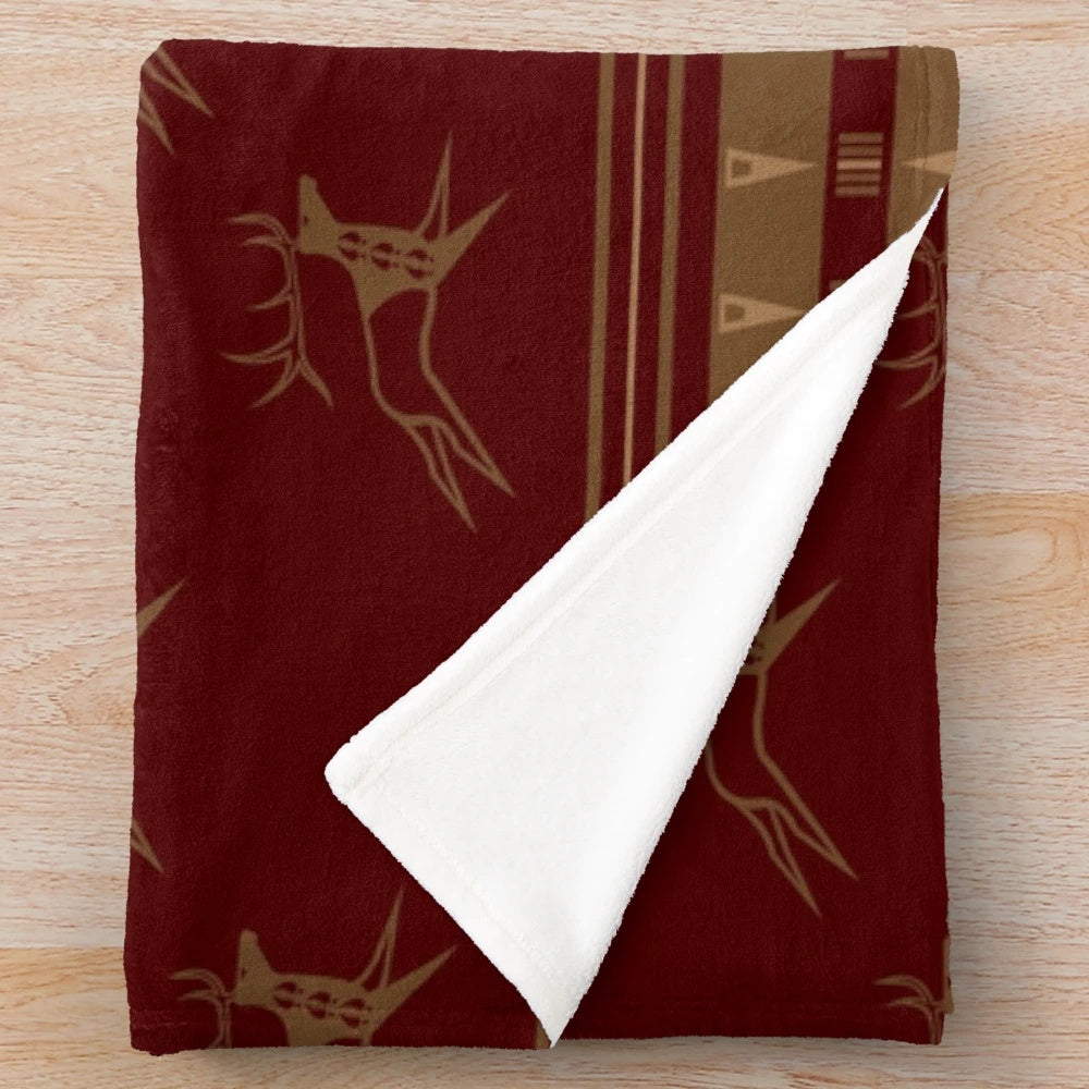 Maroon and gold plush blanket featuring a running elk design, inspired by native american art and wildlife