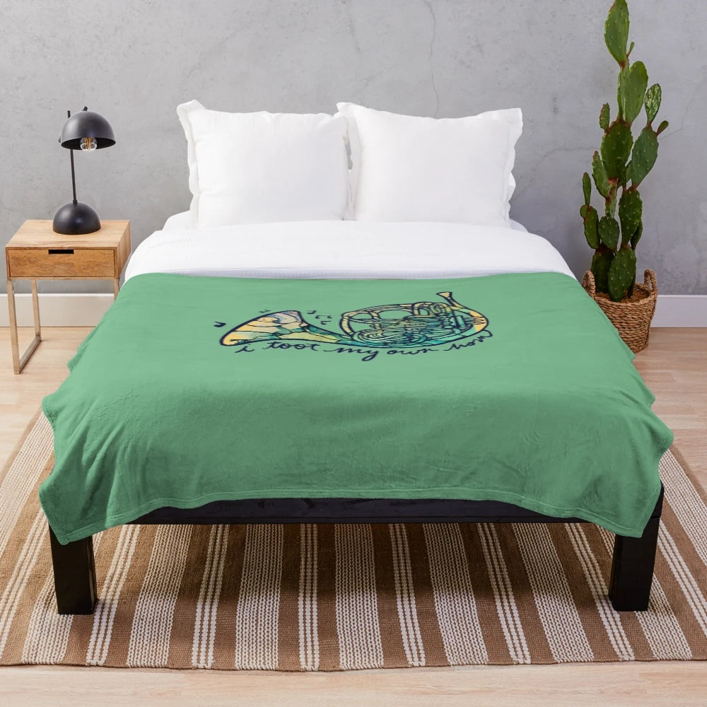 Cozy plush blanket featuring a french horn design for music lovers
