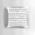 A plush, decorative pillow featuring a vibrant design of musical notes and sheet music, perfect for music enthusiasts.