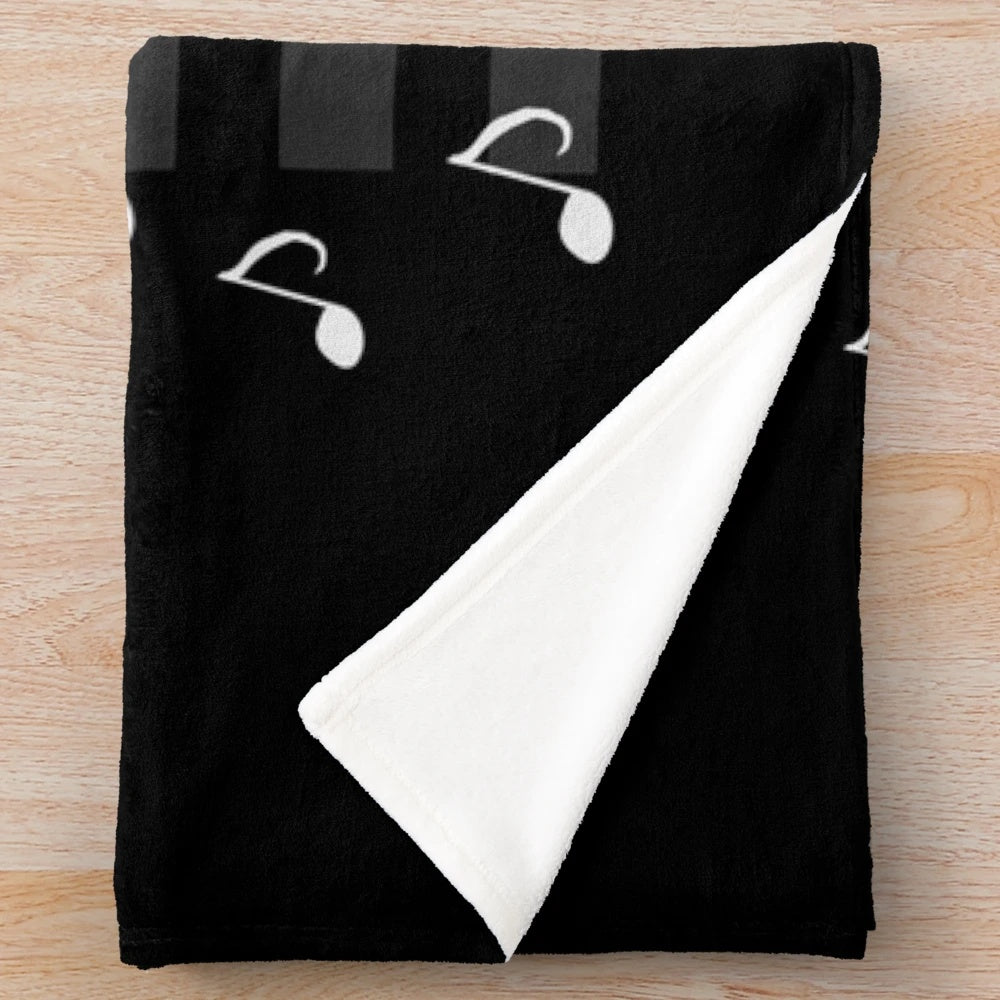 Plush blanket featuring piano keys and music notes design, perfect for music lovers