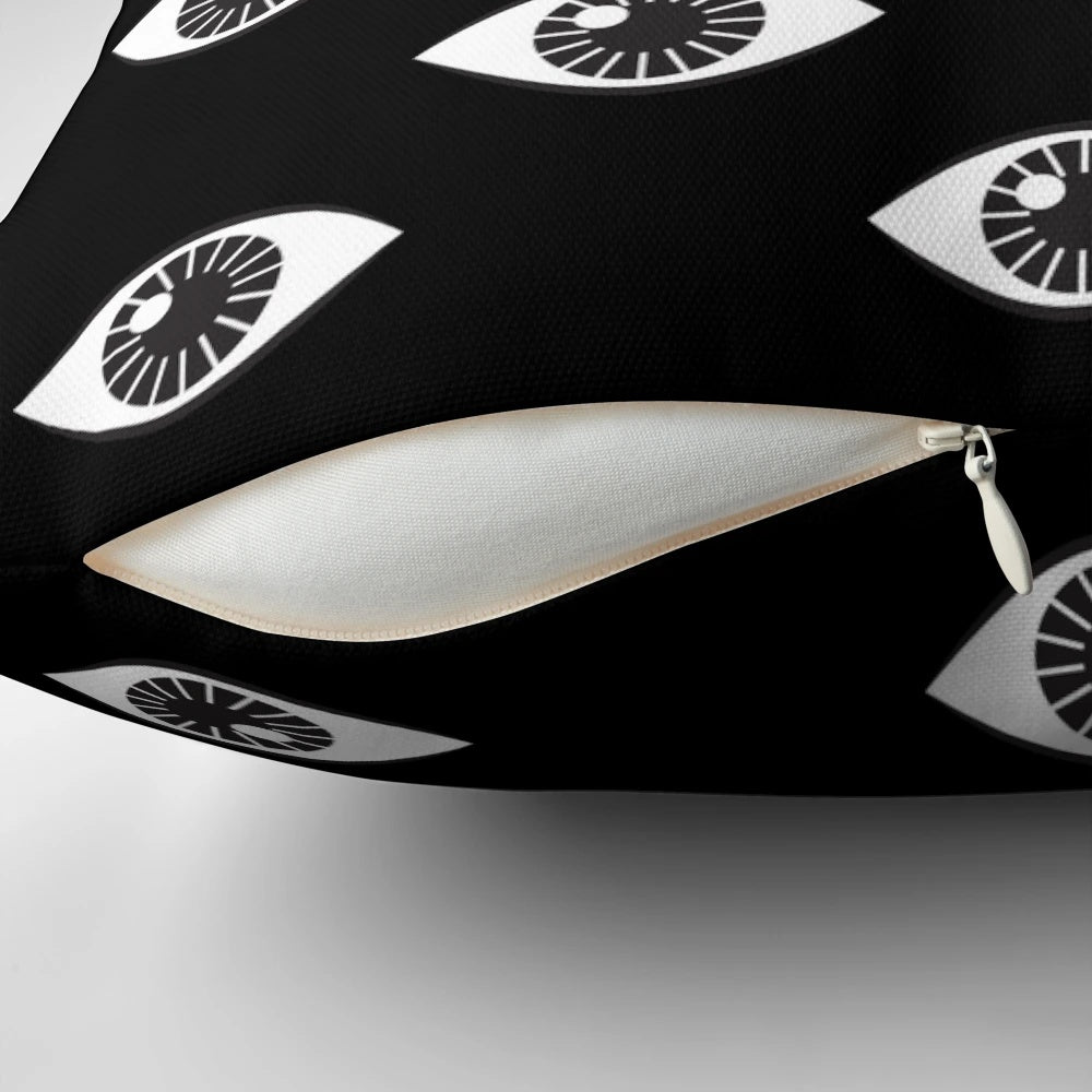 Close-up of a modern, minimalist black and white pillow with a hypnotic 'eyes wide open' pattern design.