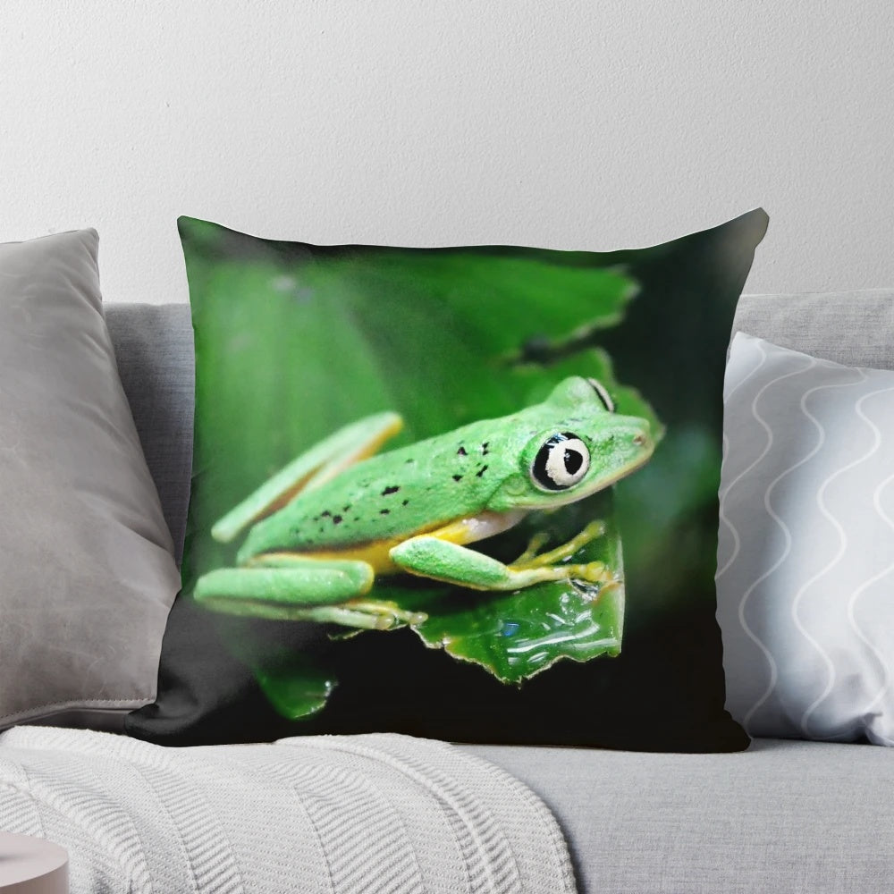 Detailed image of a realistic green frog face on a plush pillow, perfect for adding a touch of the tropics to your home.