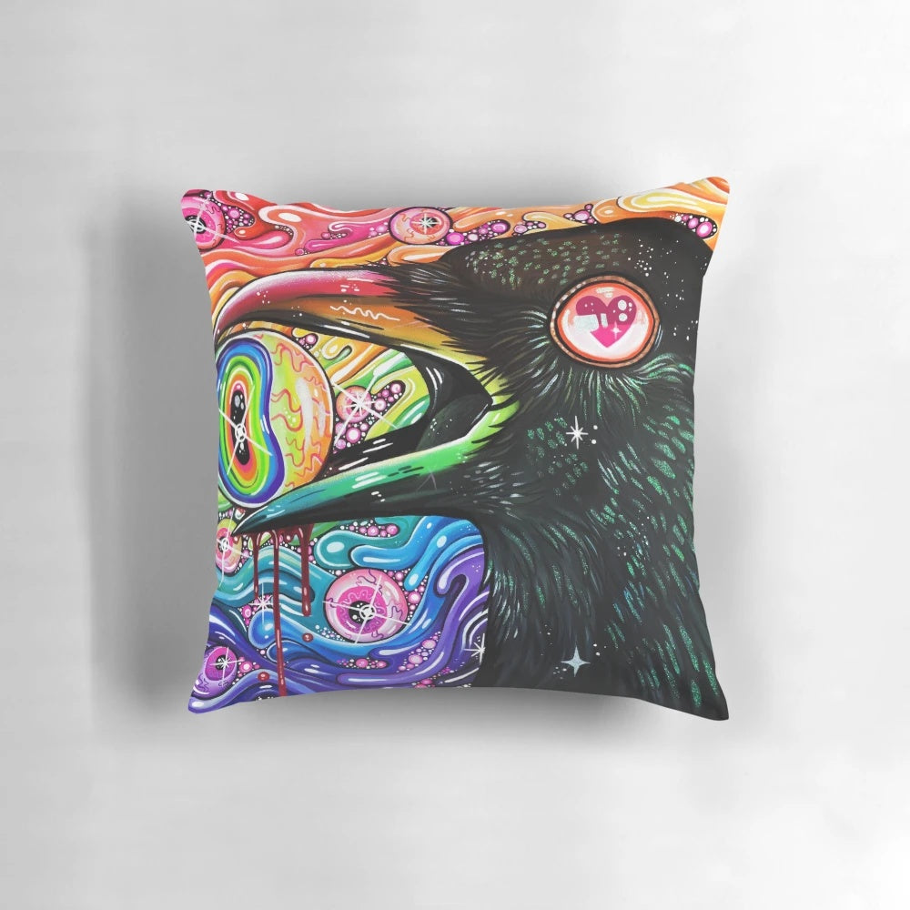A decorative throw pillow featuring a vibrant, psychedelic image of a crow with glittering feathers and intense eyes.