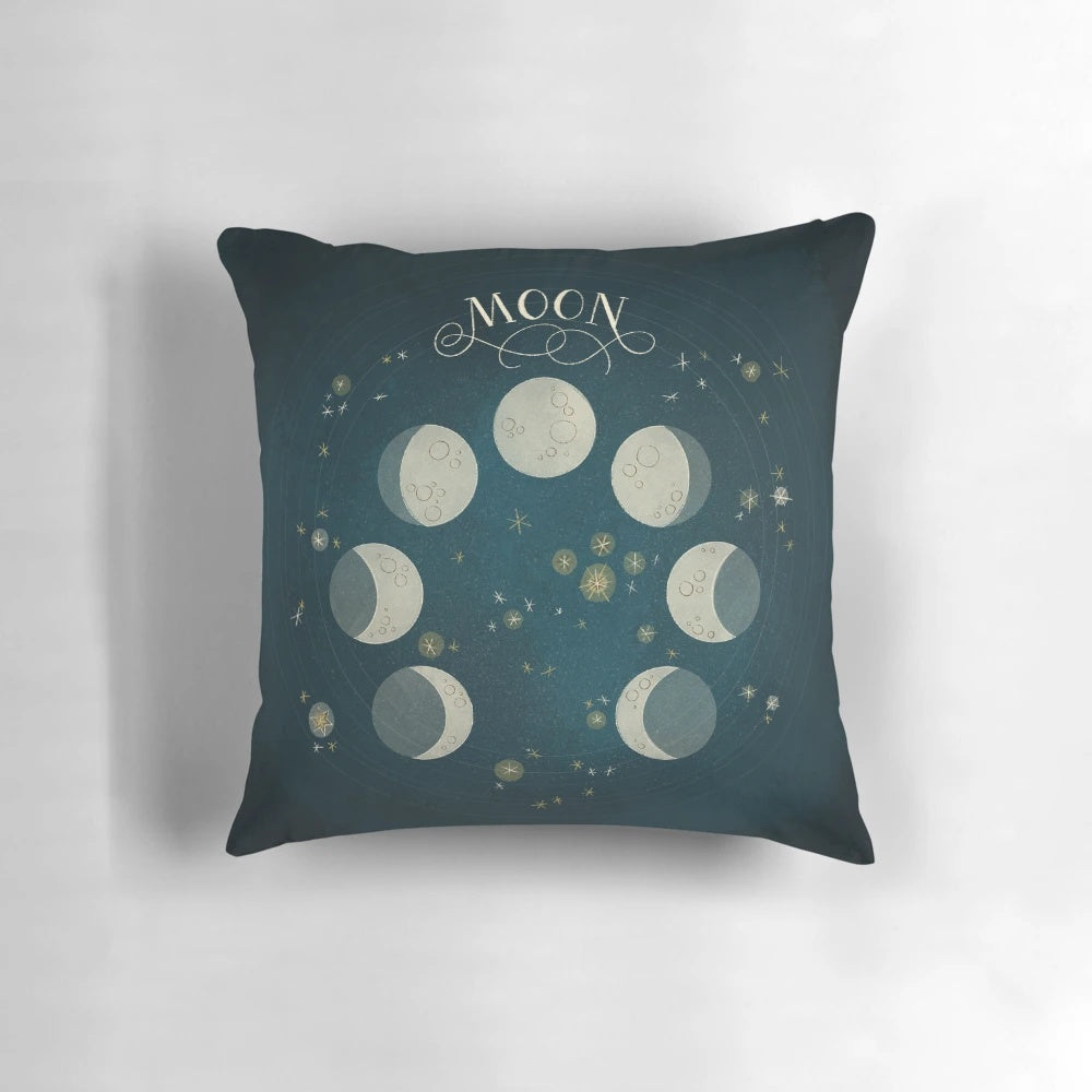 A decorative pillow featuring the different phases of the moon against a starry night sky background.