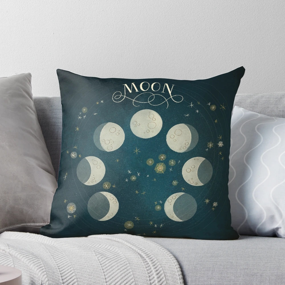 A decorative pillow featuring the different phases of the moon against a starry night sky background.