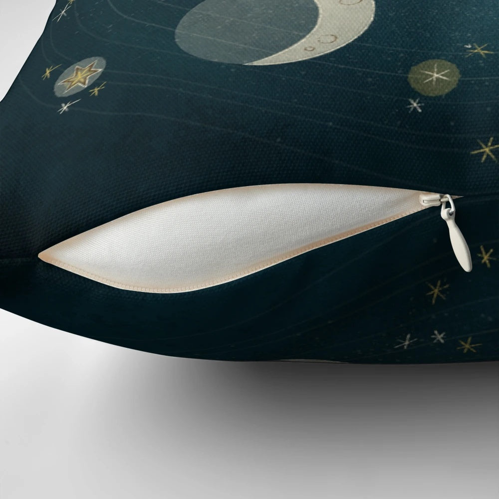 A decorative pillow featuring the different phases of the moon against a starry night sky background.