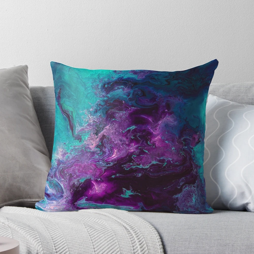 Closeup of a vibrant, abstract pillow featuring swirling shades of purple, teal, and turquoise, resembling a cosmic nebula.