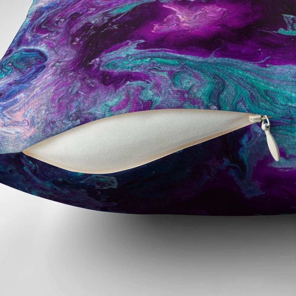 Closeup of a vibrant, abstract pillow featuring swirling shades of purple, teal, and turquoise, resembling a cosmic nebula.