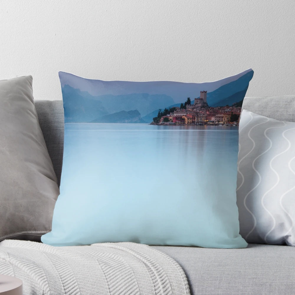 Stunning long exposure shot of Malcesine Castle reflected in the glass-like waters of Lake Garda, Italy at night.