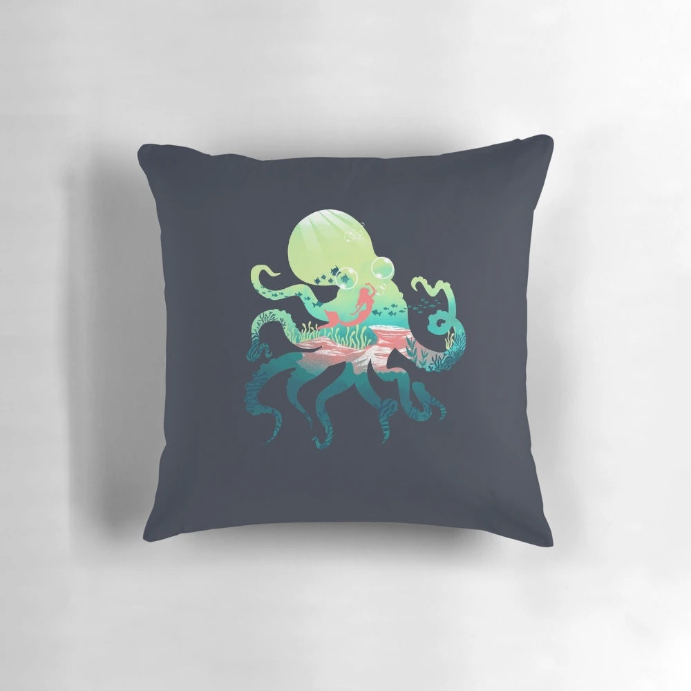 A decorative ocean-themed pillow featuring abstract mermaid and octopus designs in a negative space style.