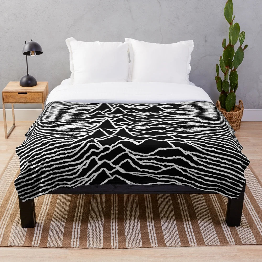 Plush blanket featuring the iconic "Unknown Pleasures" album cover design