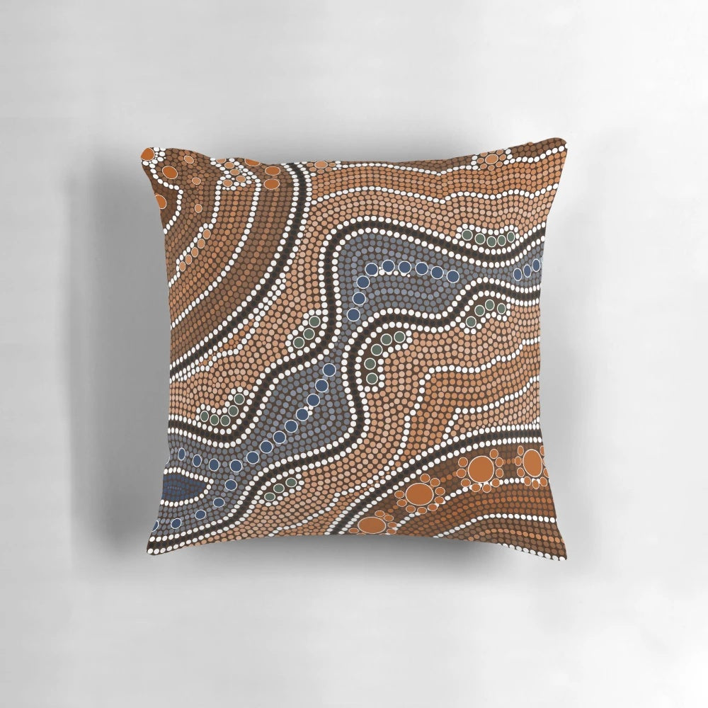 Decorative pillow with a mandala-inspired pattern of colorful points and blossoms
