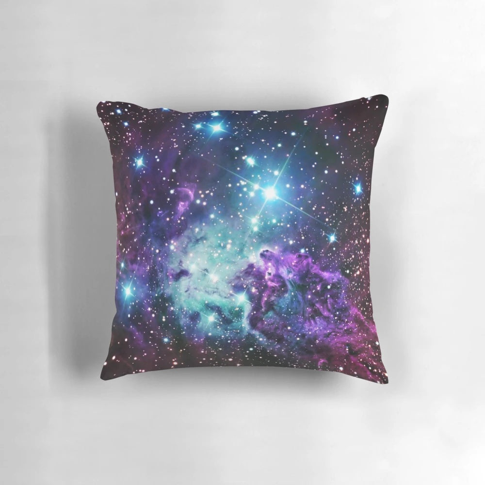 Turquoise, teal, and purple nebula-inspired pillow with a cosmic, galaxy-like design