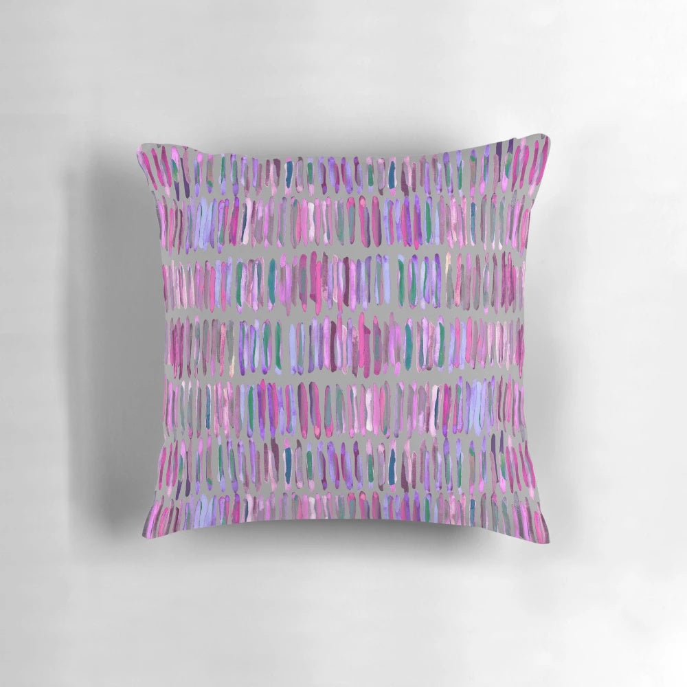 Messy watercolor stripes in pink and purple on a throw pillow