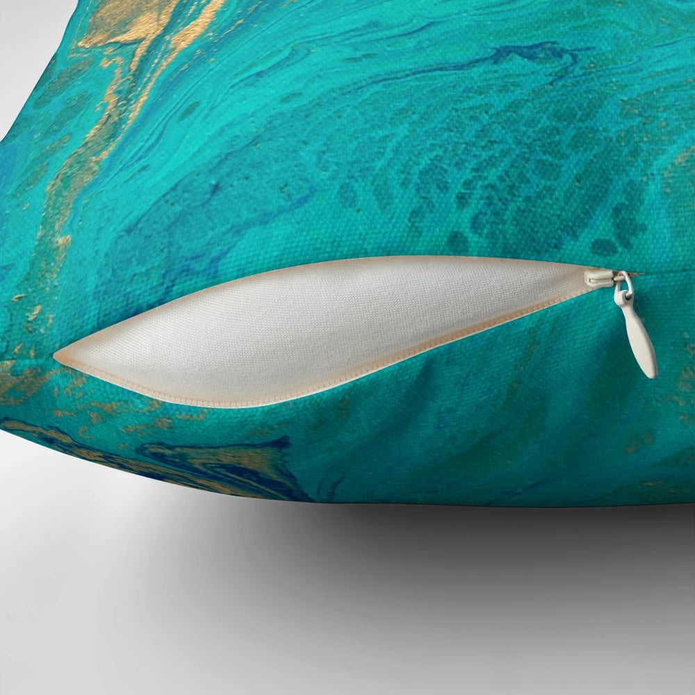 Vibrant blue, gold, and teal fluid painting design on a square throw pillow