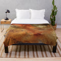 Metallic plush blanket with swirling abstract liquid art in gold, bronze, and copper tones