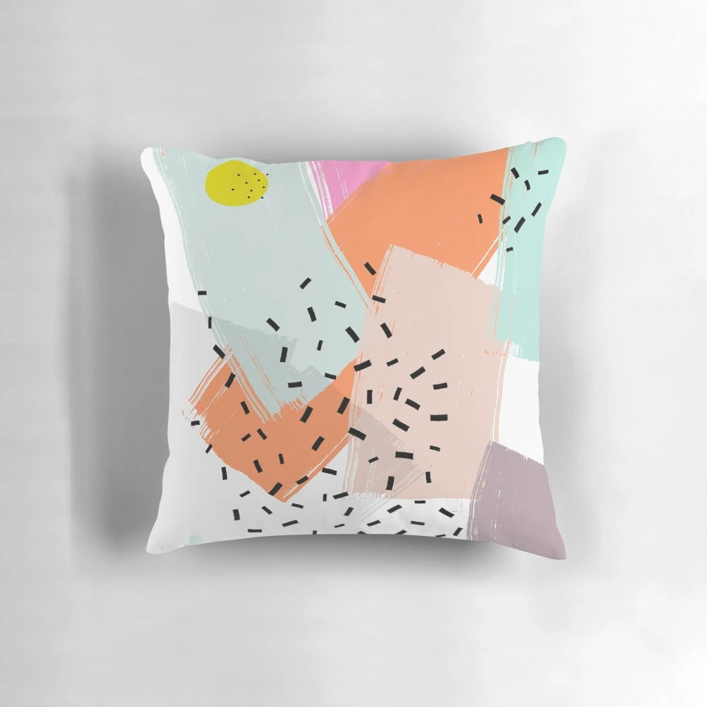 A vibrant abstract pattern pillow with geometric shapes, dots, and dashes in a mid-century modern style.