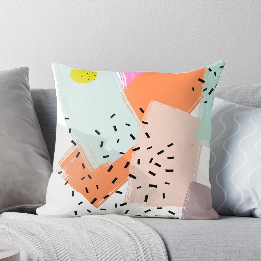 A vibrant abstract pattern pillow with geometric shapes, dots, and dashes in a mid-century modern style.