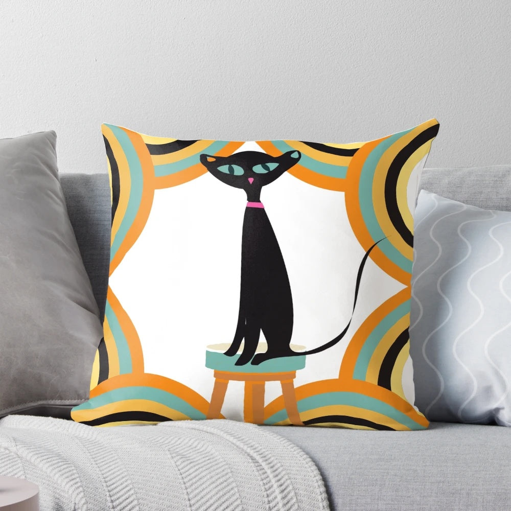 A black cat sitting among a variety of retro-styled shapes and patterns on a mid-century modern-inspired throw pillow.