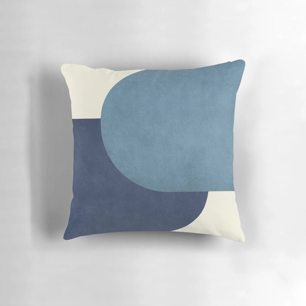 A blue and navy half circle colorblock pillow in a mid-century modern style.