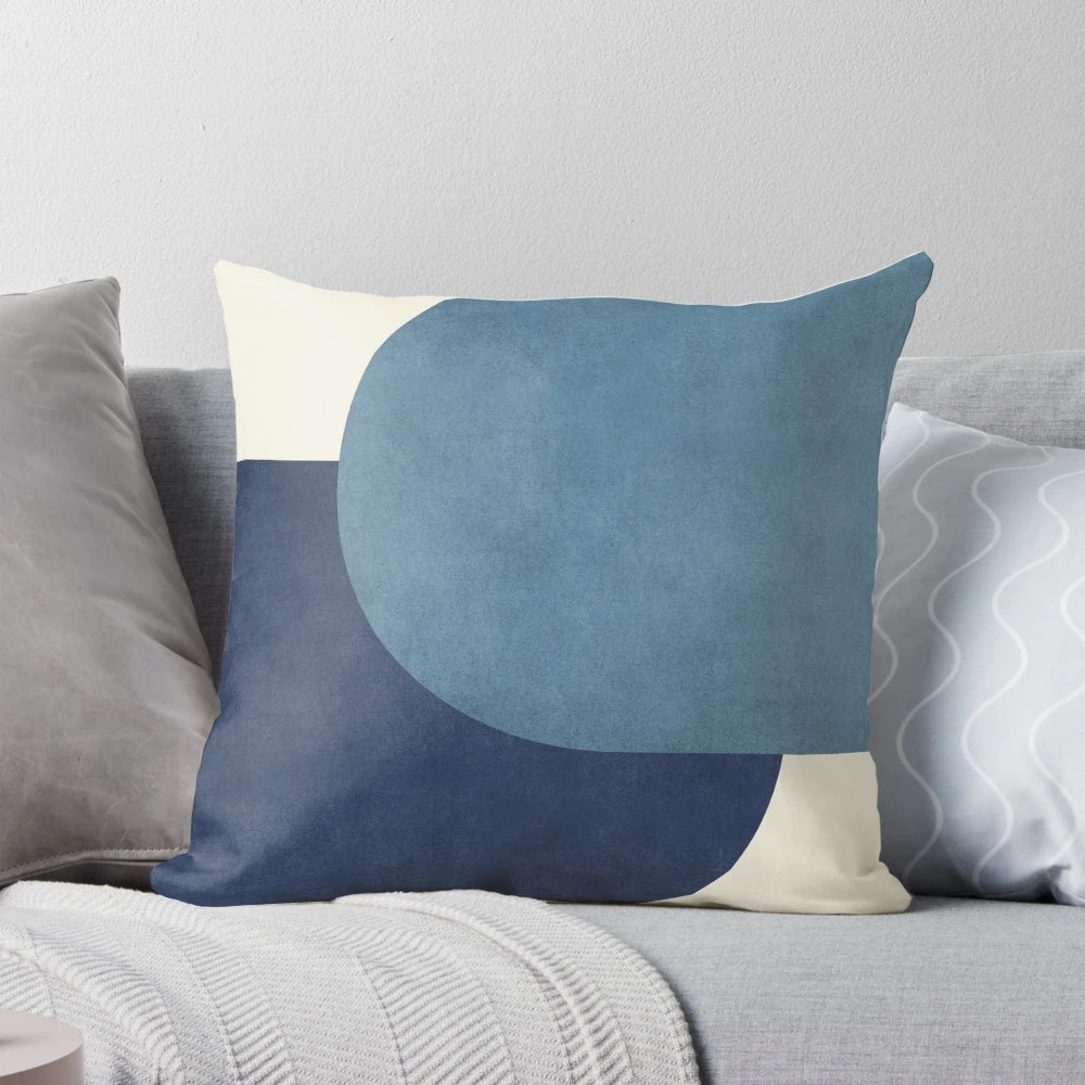 A blue and navy half circle colorblock pillow in a mid-century modern style.