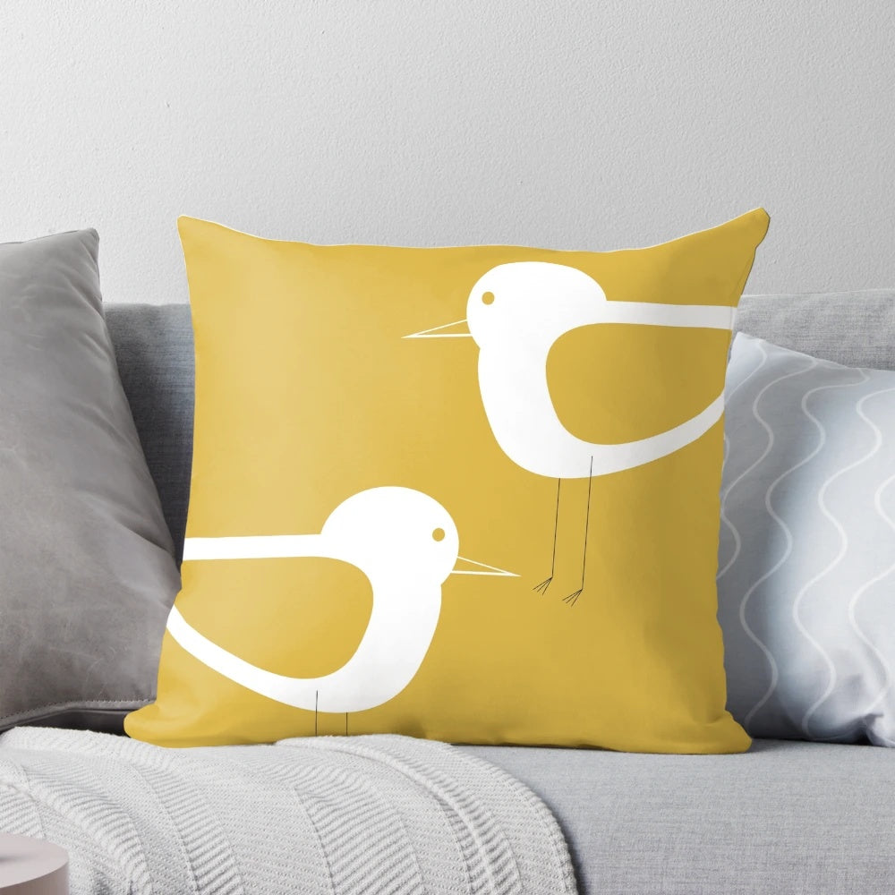 Minimalist coastal pillow featuring a pair of shorebirds in light mustard yellow and white
