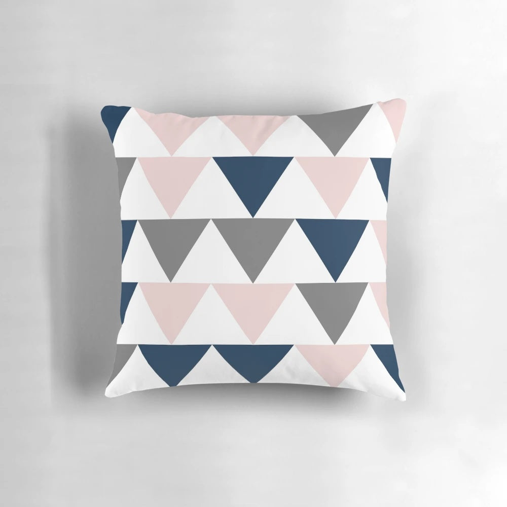 Minimalist geometric contemporary design pillow with a pattern of arrows in navy blue, charcoal grey, and blush pink on a white background
