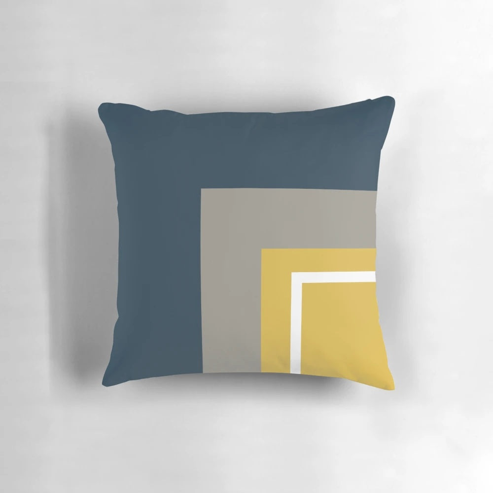 Minimalist geometric pattern pillow with a neutral color palette of mustard, navy, and gray.