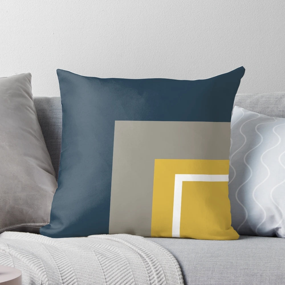 Minimalist geometric pattern pillow with a neutral color palette of mustard, navy, and gray.