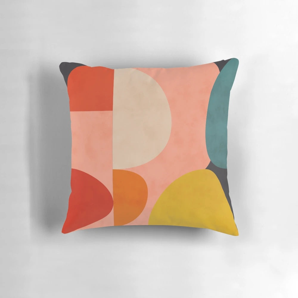 Geometric abstract patterns in pink, yellow, and blue shades on a modern decorative pillow.