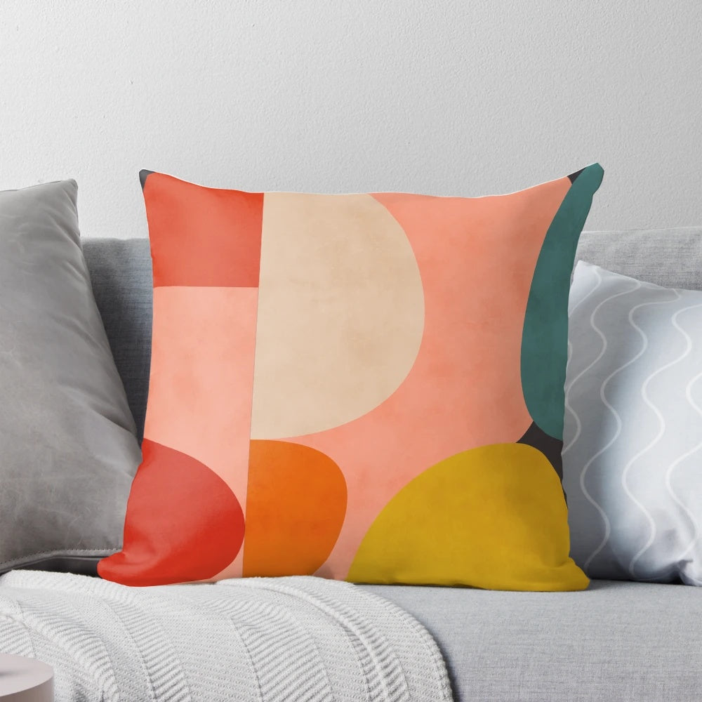 Geometric abstract patterns in pink, yellow, and blue shades on a modern decorative pillow.