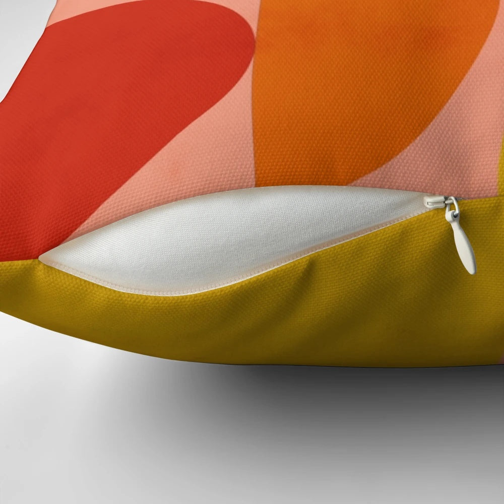 Geometric abstract patterns in pink, yellow, and blue shades on a modern decorative pillow.
