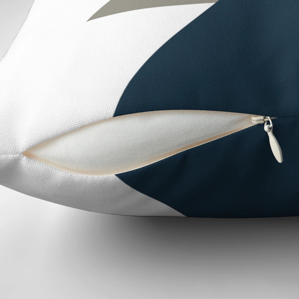A minimalist, geometric pillow featuring a triangle pattern in light mustard yellow, white, grey, and navy blue.